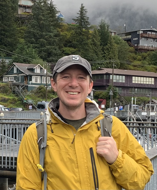 Picture of me standing on a dock in a yellow rain coat and old Seattle Mariners cap.